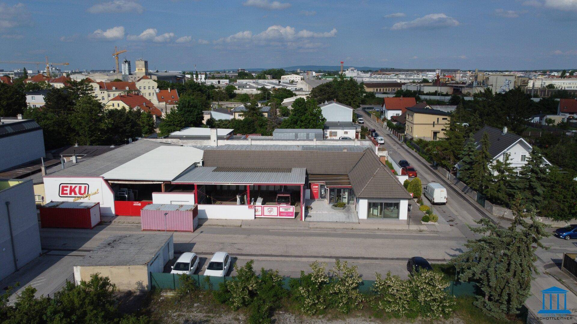 Überblick aus der Vogelperspektive auf das Geschäftshaus und die umliegende städtische und grüne Landschaft.