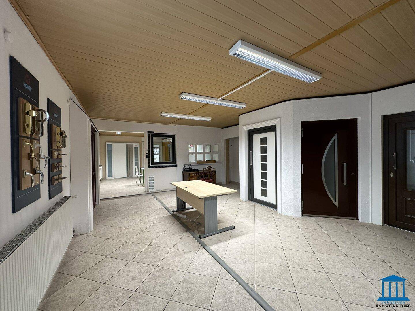 Ausstellungsbereich mit verschiedenen Türmodellen und Türgriffen, ergänzt durch eine Holzpaneeldecke und Fliesenboden.