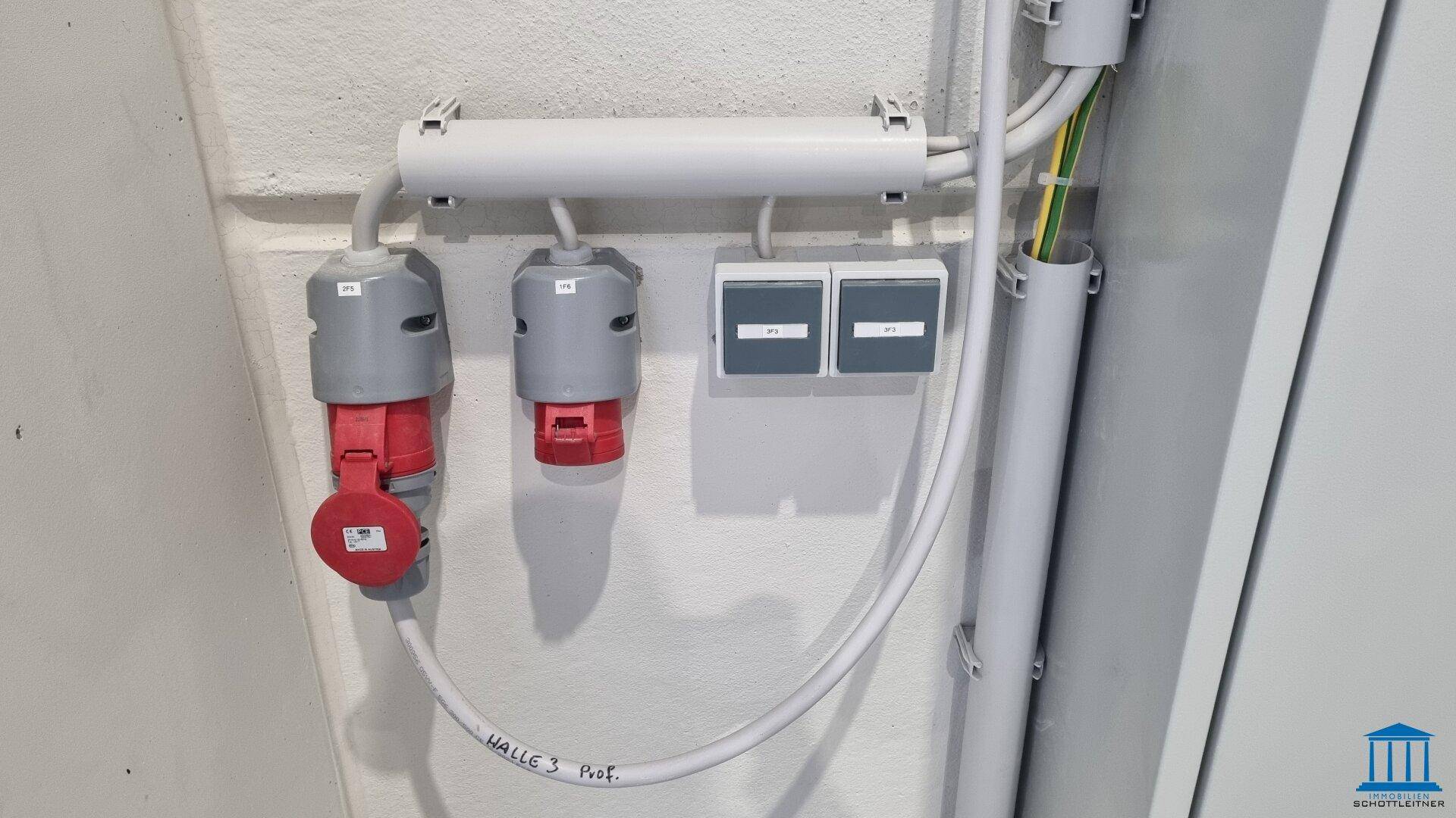 Industrielle Steckdosen und elektrische Anschlüsse an einer Wand.