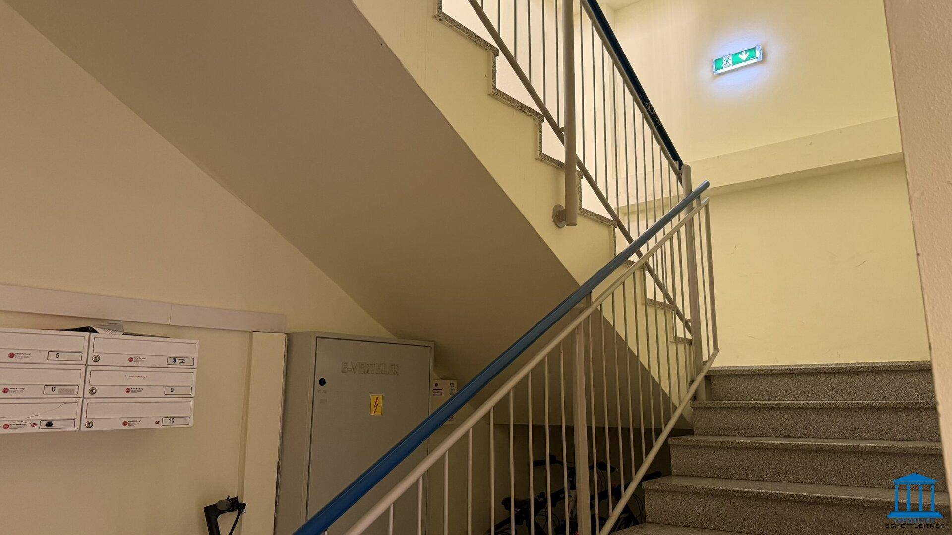 Treppenhaus mit robustem Geländer und Granitstufen, führt zu den oberen Etagen.