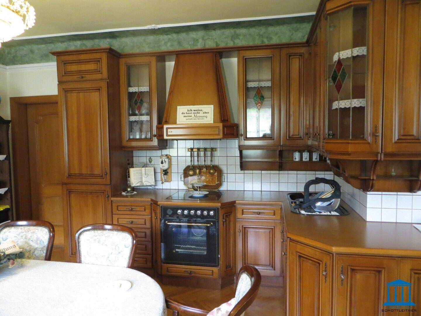 Traditionelle Holzküche mit Einbauschränken, Fliesenrückwand und integriertem Herd.