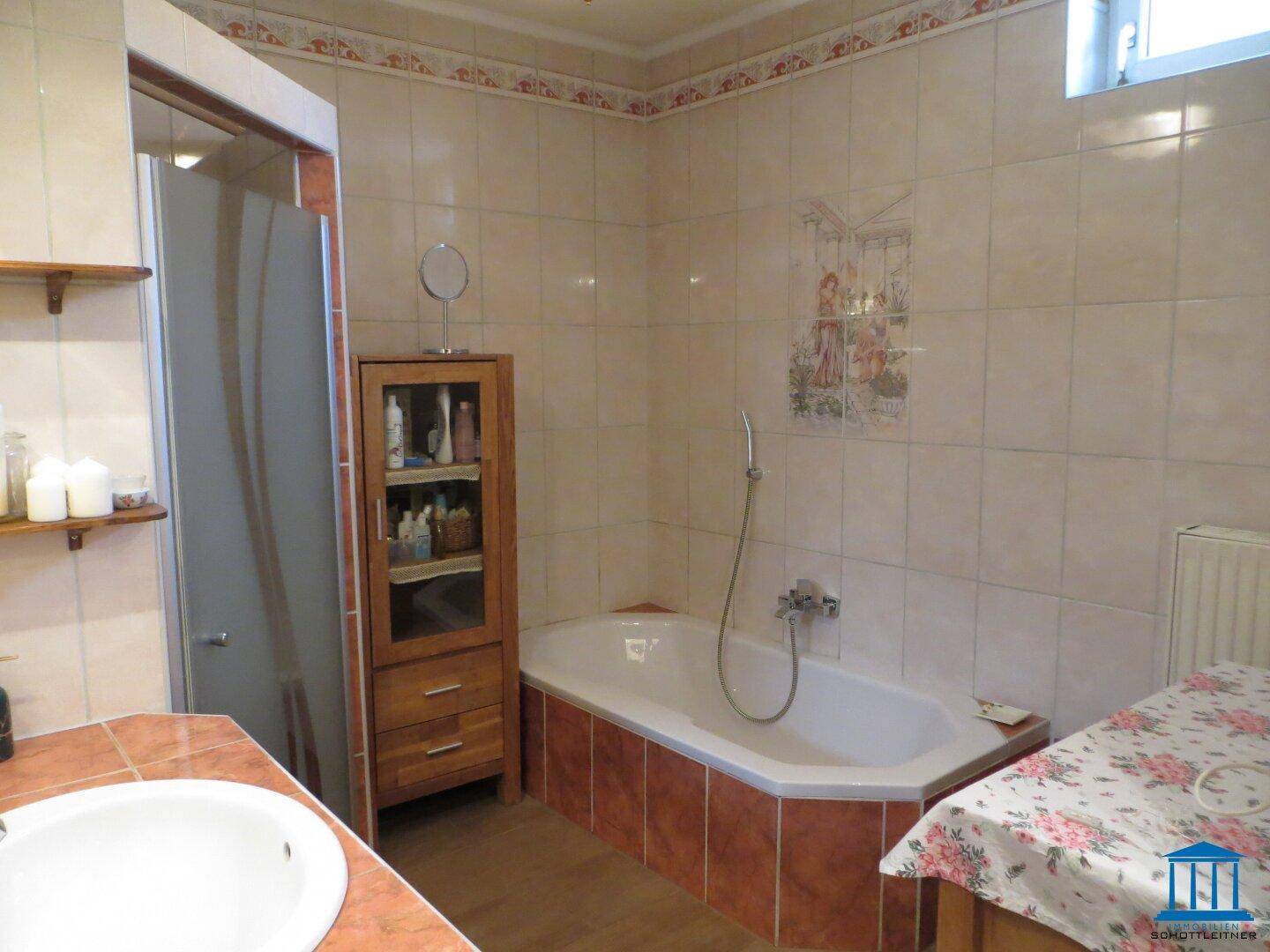Helles Badezimmer mit Eckbadewanne, Duschkabine und gefliesten Wänden.