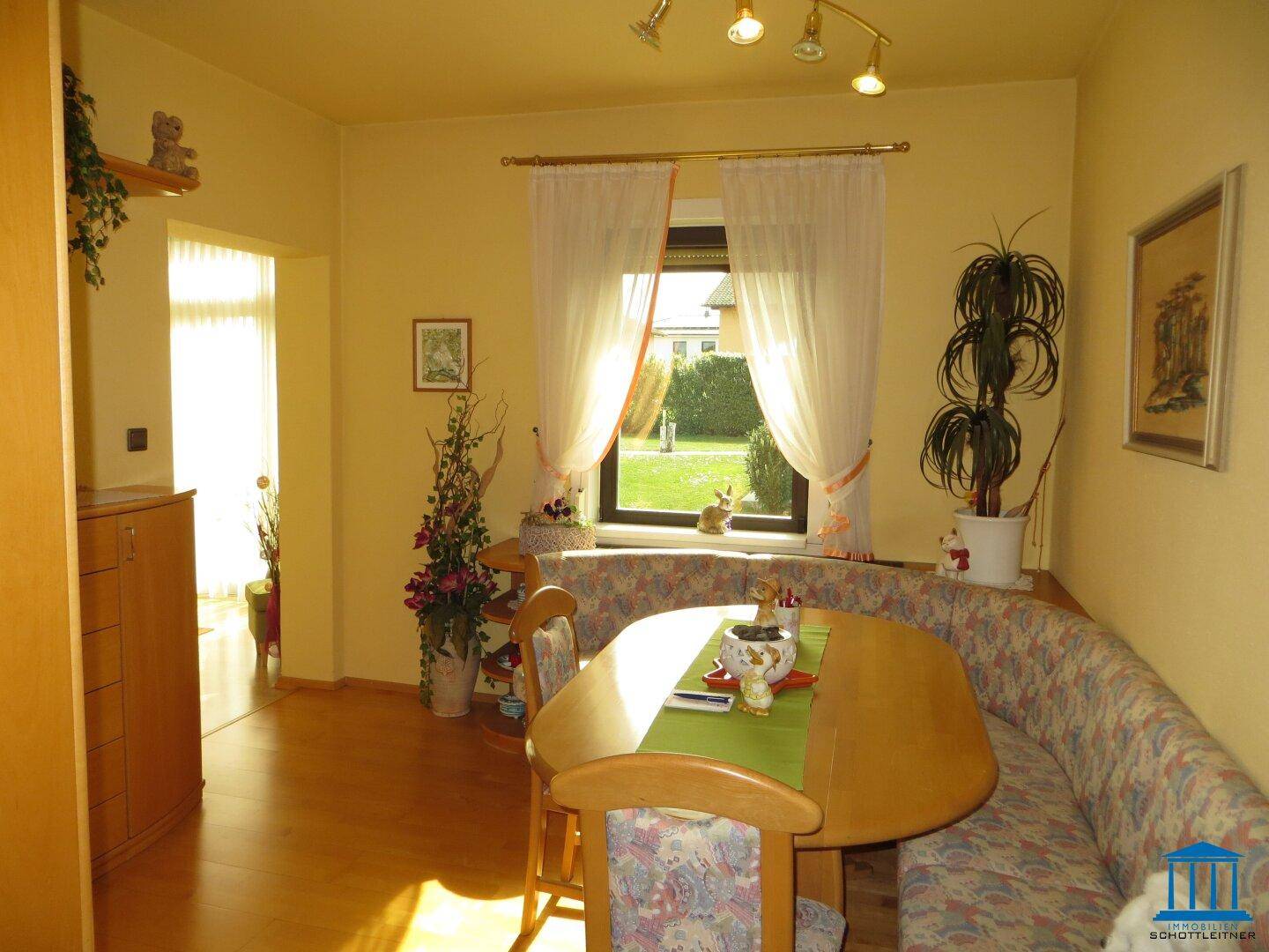Gemütlicher Essbereich mit Holztisch, Eckbank und Blick in den Garten.