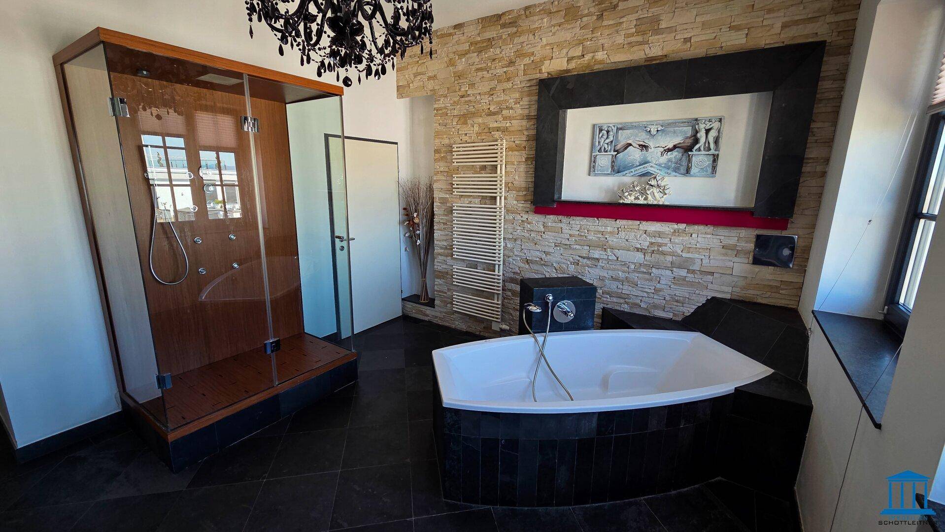 Geräumiges Badezimmer mit Eckbadewanne, großer Duschkabine und Steinwand.