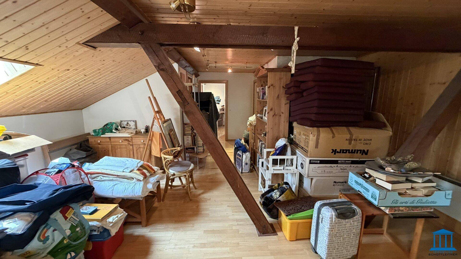 Dachboden mit Holzdecke und sichtbaren Balken, als Stauraum und Arbeitsbereich genutzt, vielseitig einsetzbar.
