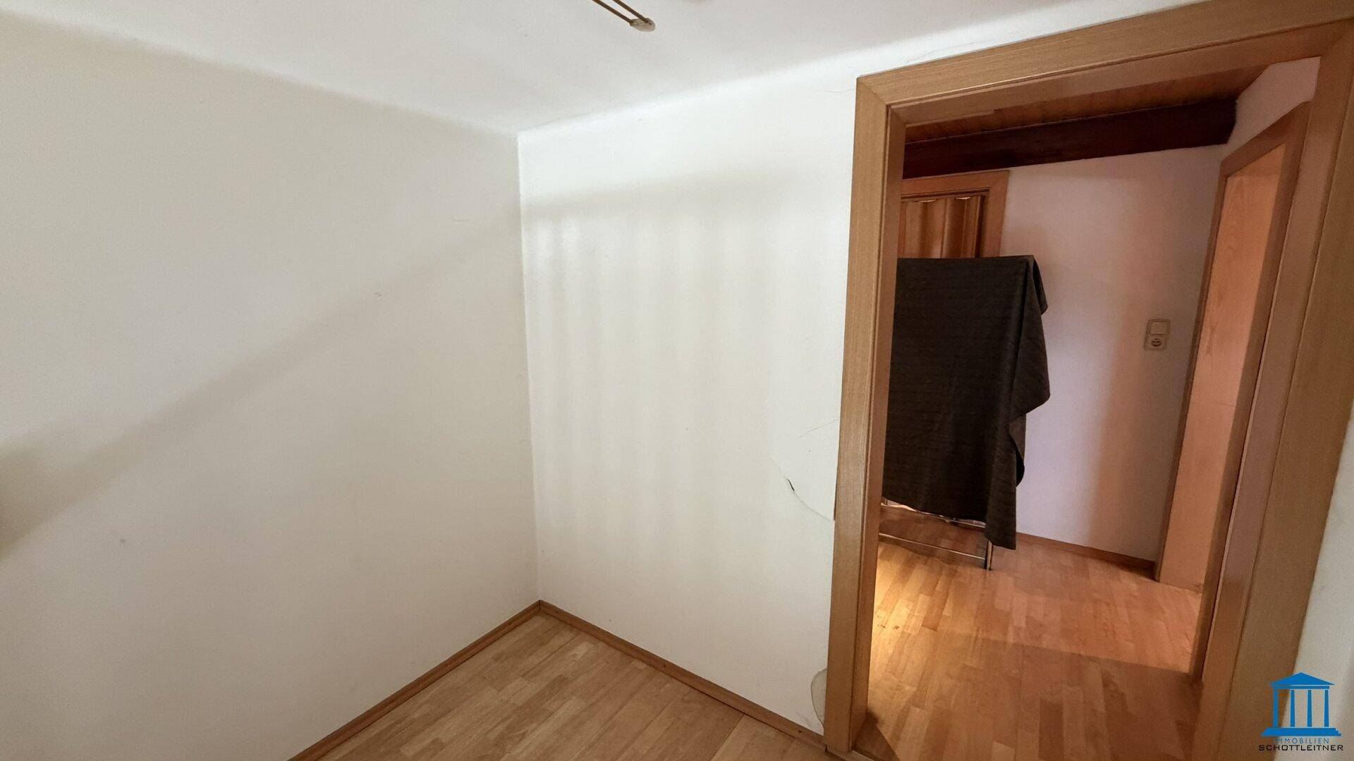 Heller Raum mit Holzboden und Türrahmen, bereit zur individuellen Gestaltung, bietet viel Potenzial.