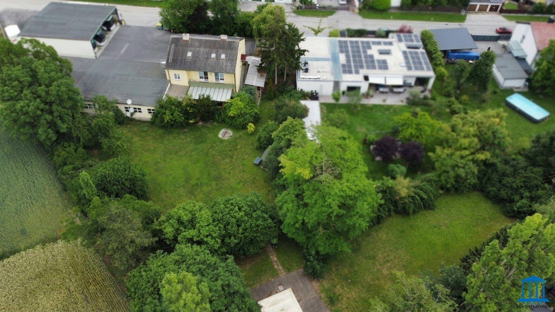 Weitläufige Luftaufnahme des gesamten Anwesens mit großem Garten und angrenzenden Nachbargrundstücken.