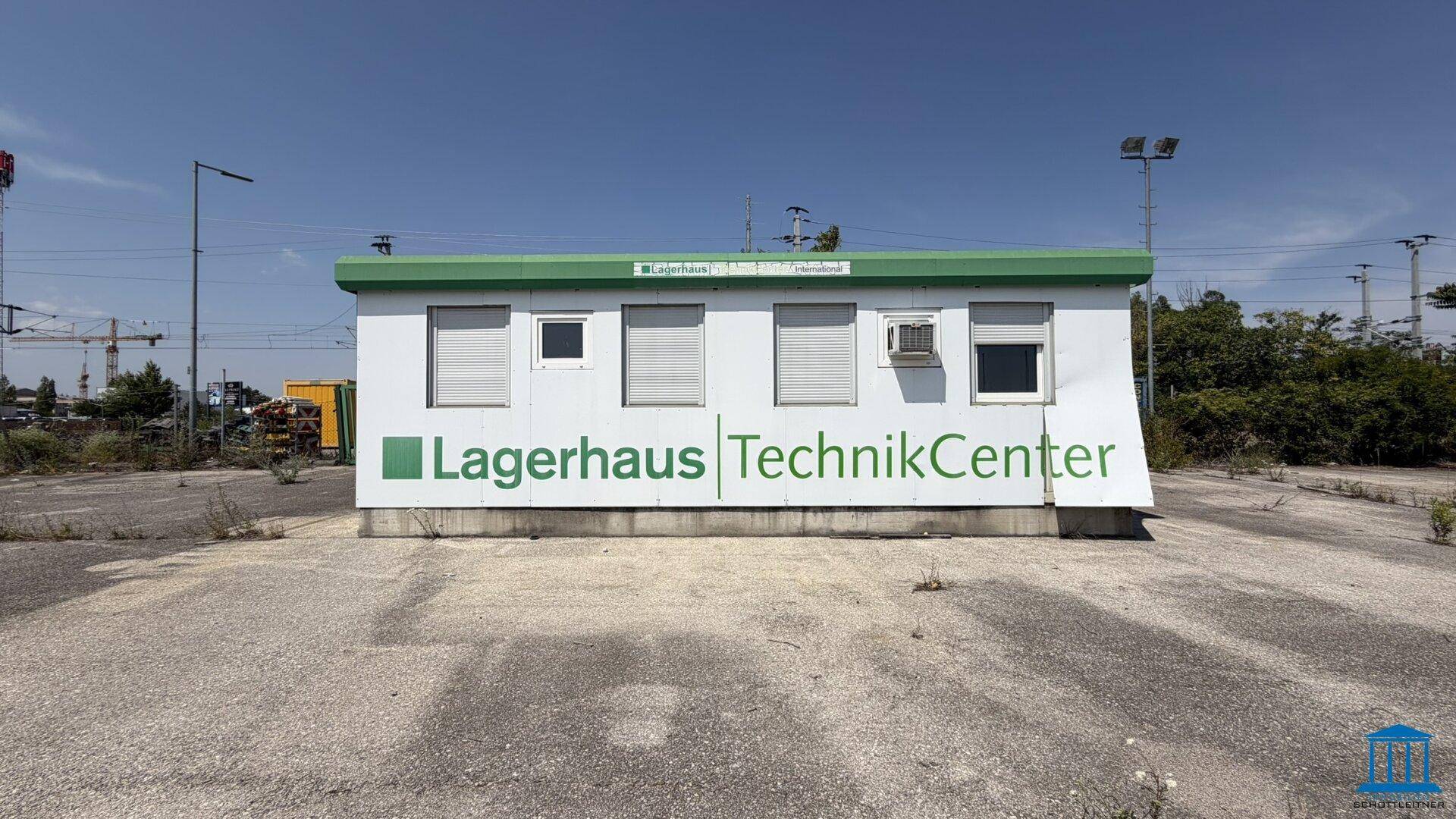 Außenansicht eines mobilen Bürocontainers mit Fenstern, Rollläden und Firmenbeschriftung.