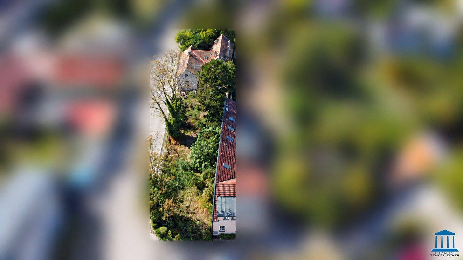 Vertikale Luftaufnahme eines Teils des Anwesens mit Gebäuden und dichter, natürlicher Vegetation.