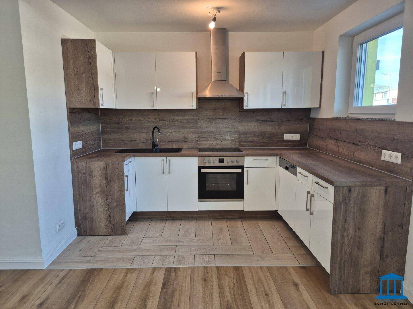Moderne Einbauküche mit weißen Hochglanzfronten, Holzoptik-Arbeitsplatten und integrierten Geräten.