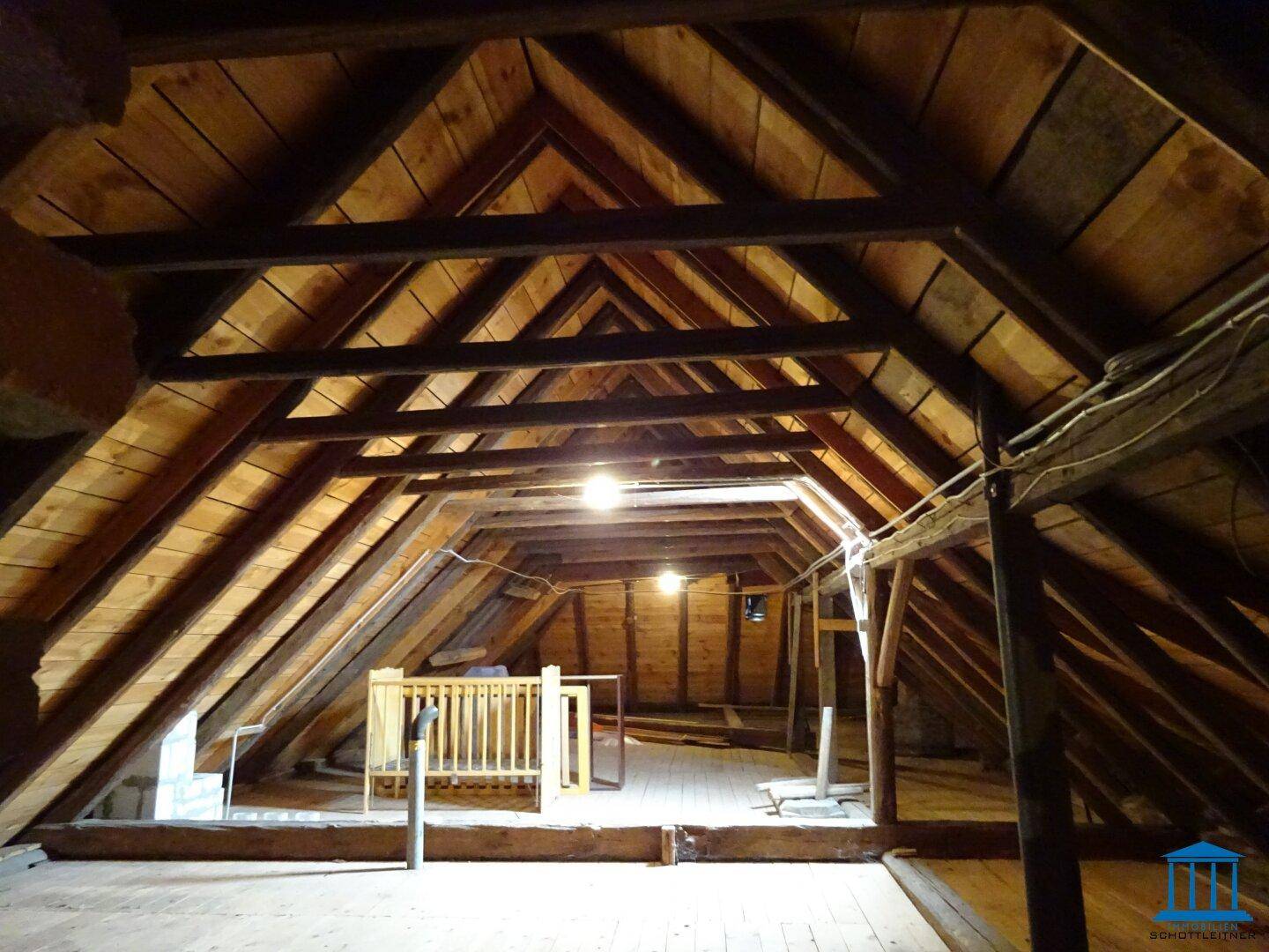 Geräumiger Dachboden mit sichtbaren Holzbalken und viel Potenzial für zukünftigen Ausbau.