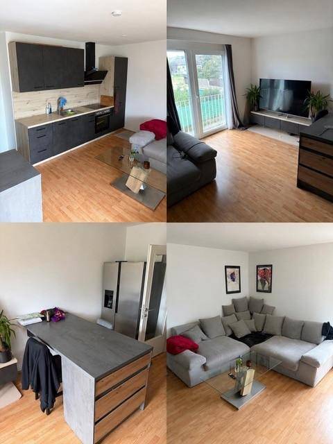 Offener Wohnbereich mit integrierter Küche, Sofa und Zugang zum Balkon.