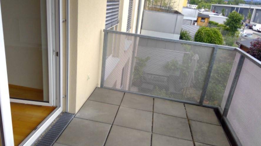 Kleiner Balkon mit Fliesenboden und modernem Metallgeländer, bietet einen Blick auf die Umgebung.