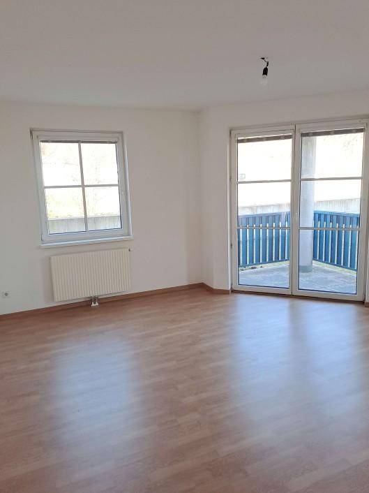 Helles Zimmer mit Laminatboden und Zugang zu einem Balkon, ideal als Wohnbereich nutzbar.
