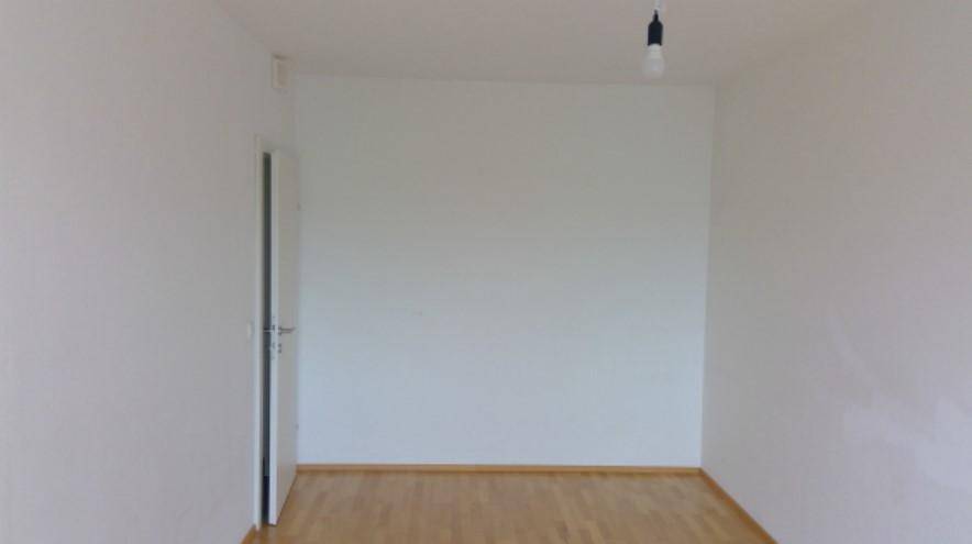 Unmöblierter Raum mit hellem Holzfußboden und weißen Wänden, bereit zur individuellen Gestaltung.