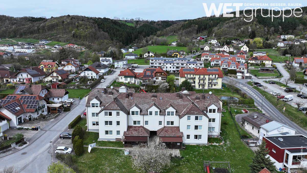 Panoramablick aus der Luft auf den Wohnkomplex, umgeben von Hügeln und ländlicher Bebauung.