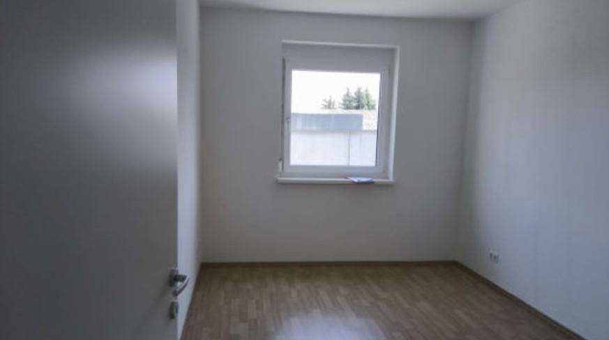 Helles Zimmer mit Holzboden und Fenster, ideal als Schlaf- oder Gästezimmer nutzbar.