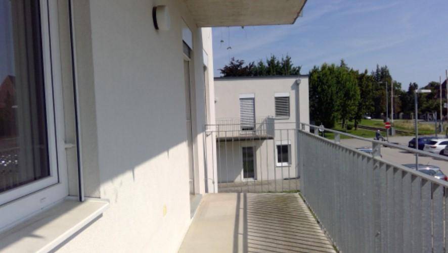 Heller Balkon mit Blick auf die Straße und umliegende Gebäude.