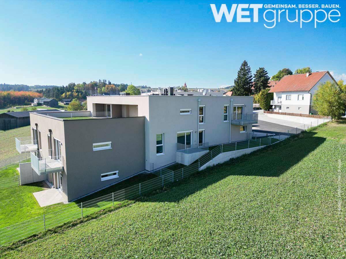 Panoramablick auf das moderne Wohnhaus, eingebettet in die grüne Landschaft mit weitem Horizont.