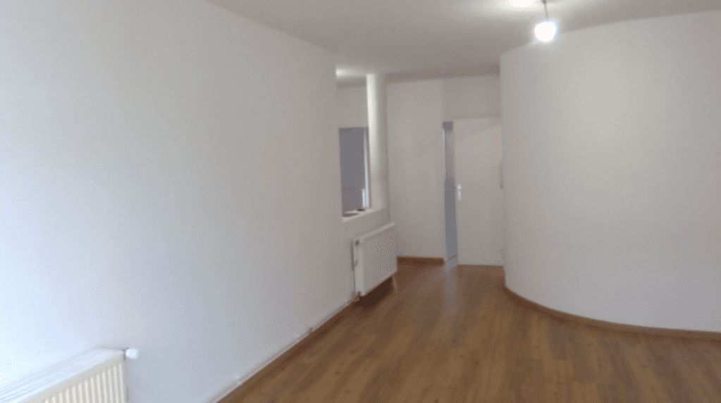 Heller Flur mit Holzboden, weißen Wänden und einer eleganten Rundung.