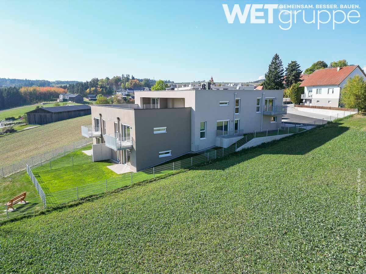 Weitläufige Ansicht des modernen Wohngebäudes in ländlicher Umgebung mit weiten Feldern.