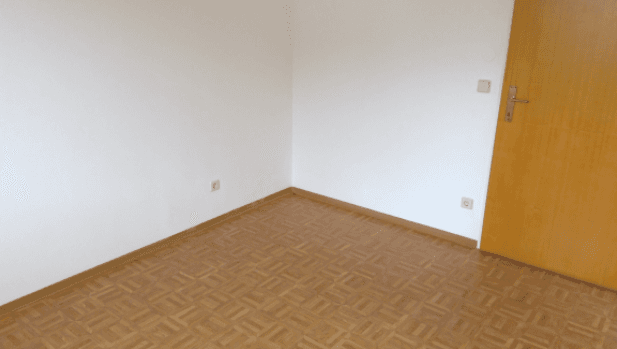 Leeres Zimmer mit hellem Parkettboden und weißen Wänden, bereit zur individuellen Gestaltung.