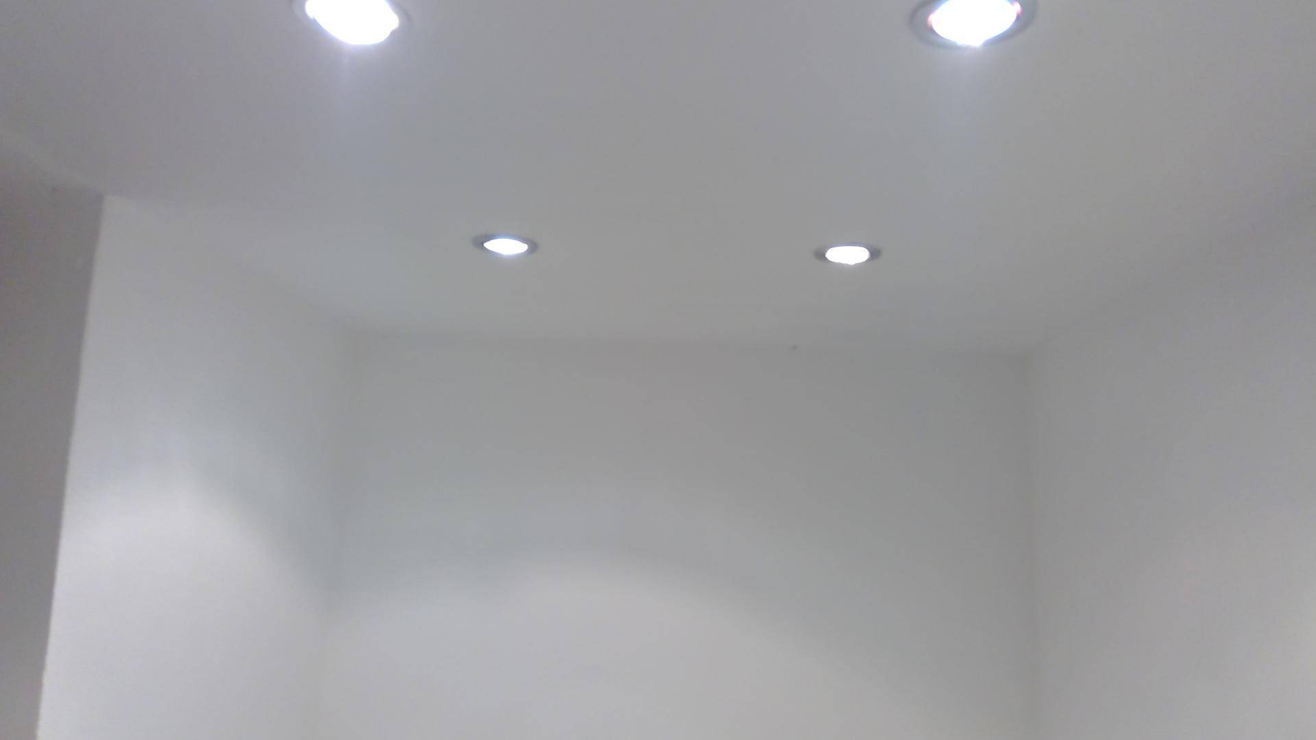 Weiße Decke eines Raumes mit vier eingebauten, modernen Deckenleuchten.