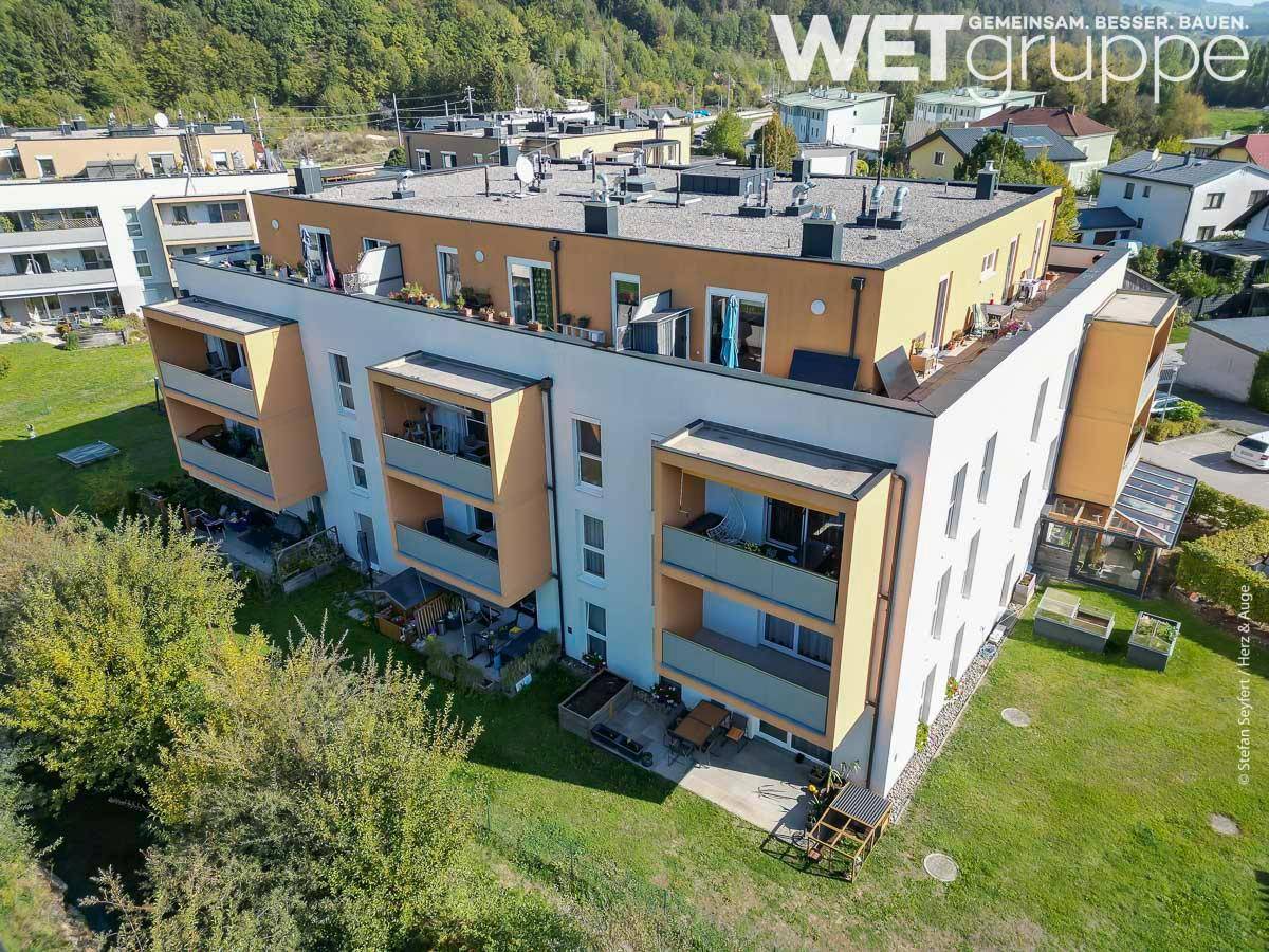 Luftaufnahme des modernen Wohnkomplexes mit Flachdach und umliegenden Grünflächen.