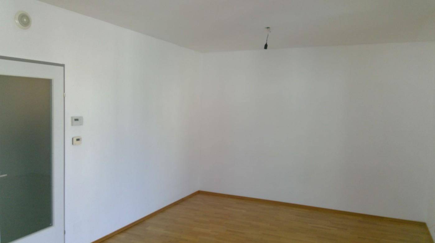 Leerer Raum mit weißen Wänden und Holzboden, bereit für individuelle Gestaltung.