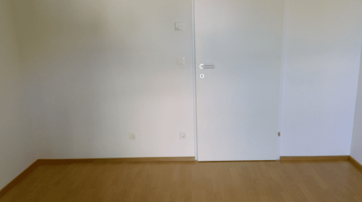 Leerer Raum mit Holzboden und weißer Tür, bereit für individuelle Gestaltung und Nutzung.