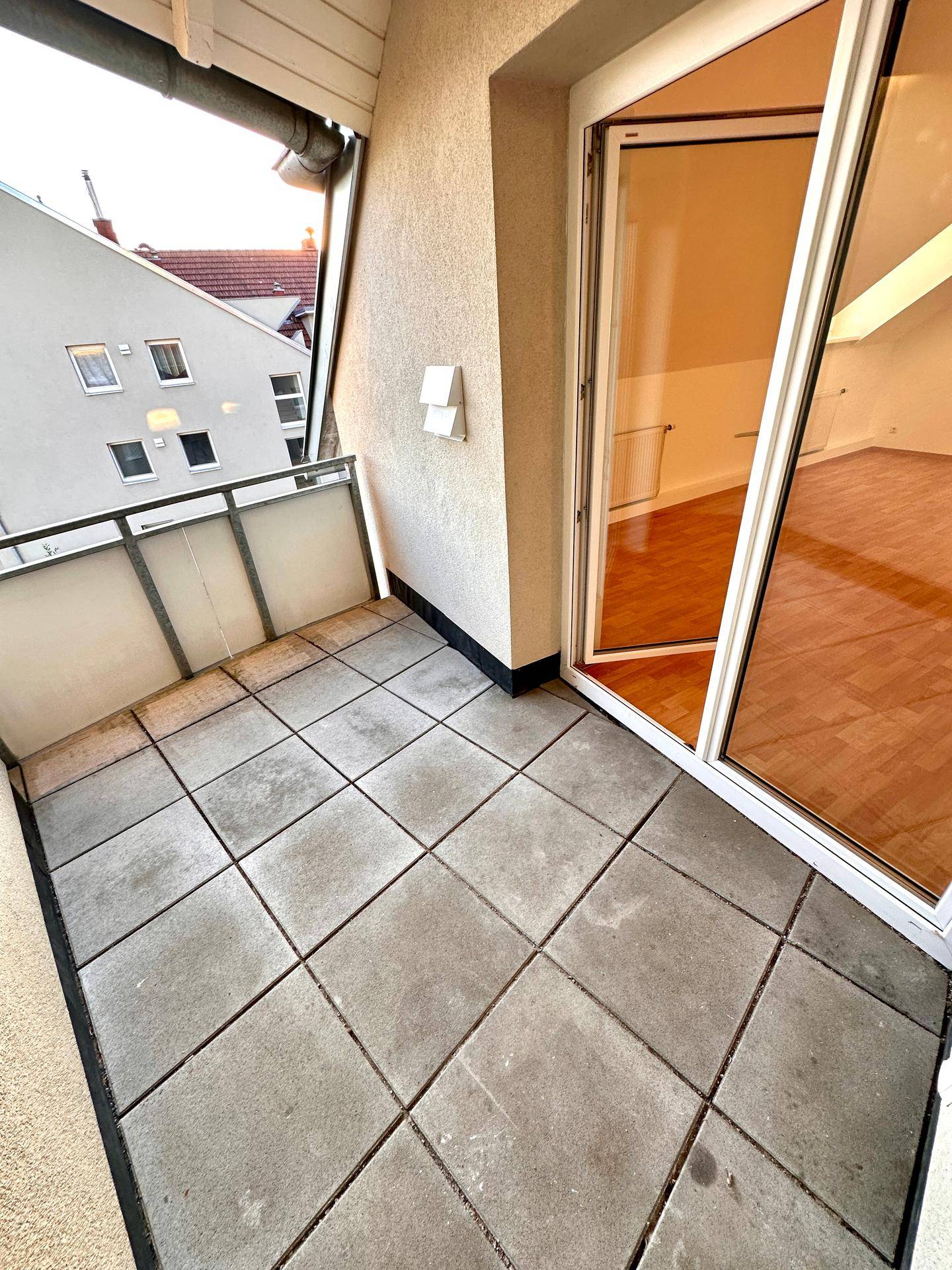Balkon mit Fliesenboden und Blick auf die umliegenden Gebäude, ideal für Entspannung.