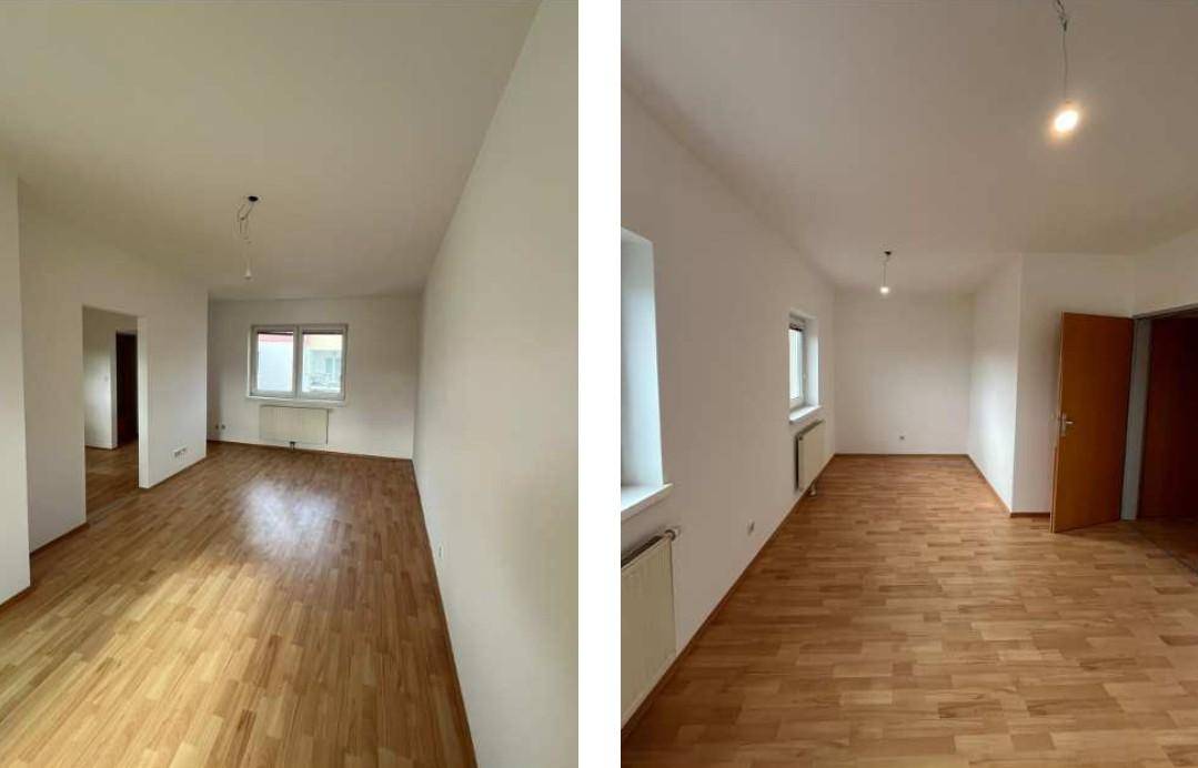 Helle, leere Räume mit Holzparkettboden, weißen Wänden und Heizkörpern unter den Fenstern.