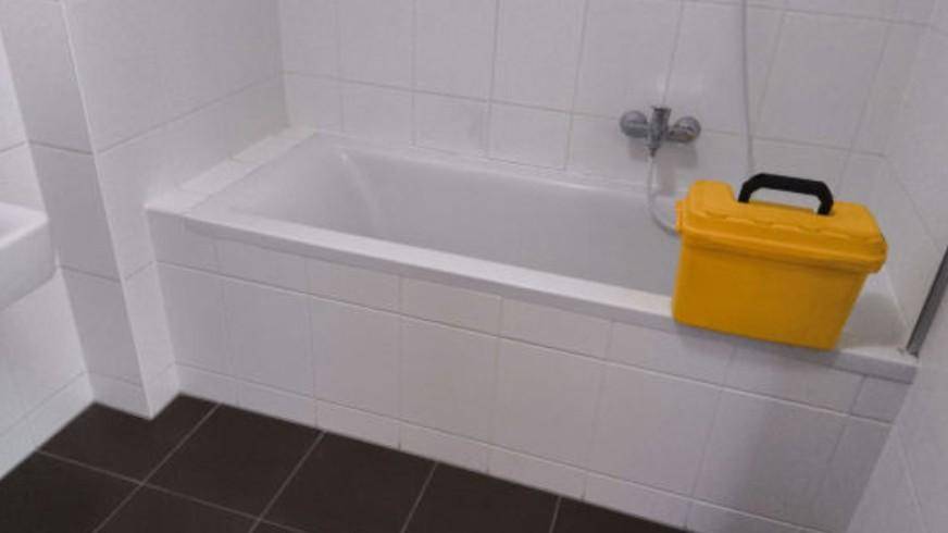 Funktionales Badezimmer mit Badewanne und weißen Fliesen, bereit zur individuellen Gestaltung.