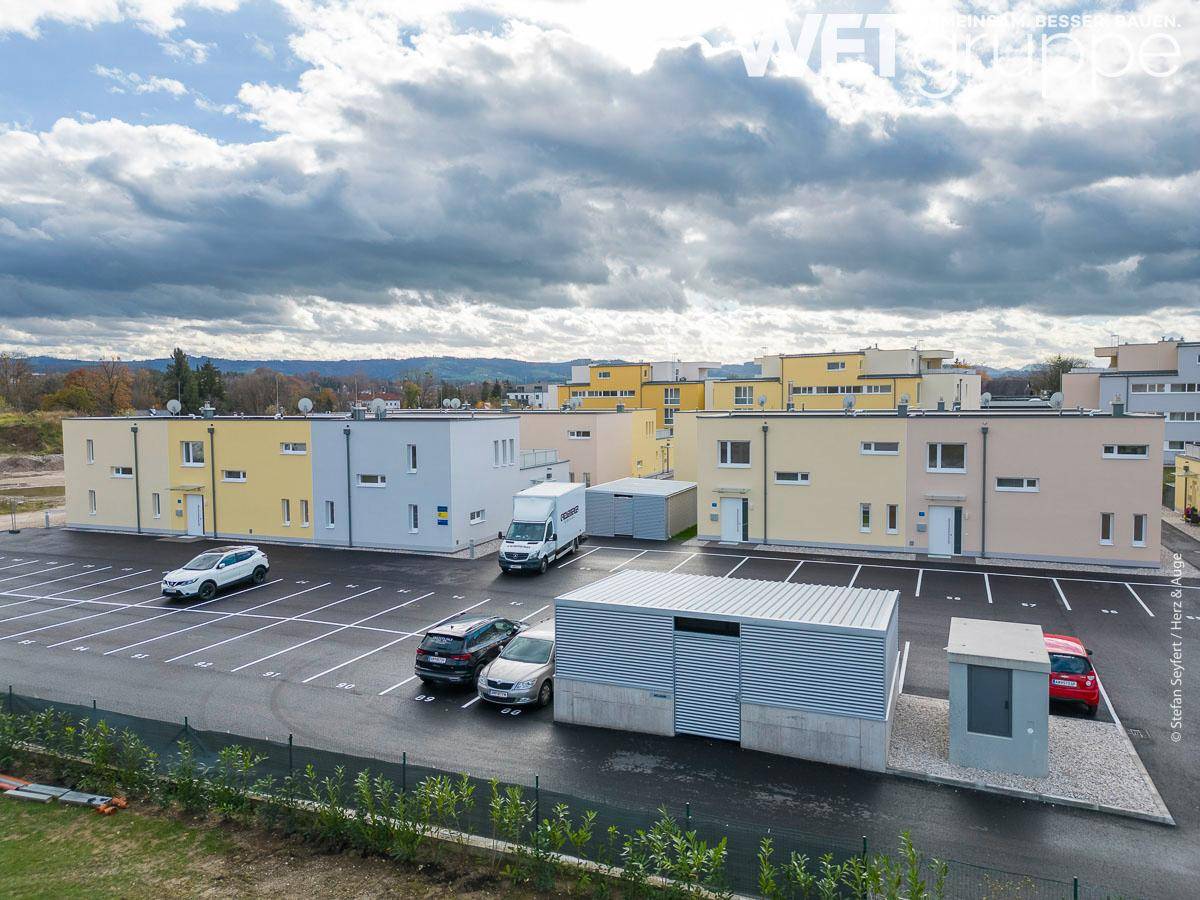 Übersicht über ein Neubaugebiet mit Reihenhäusern, Parkplätzen und kleinen Grünflächen.