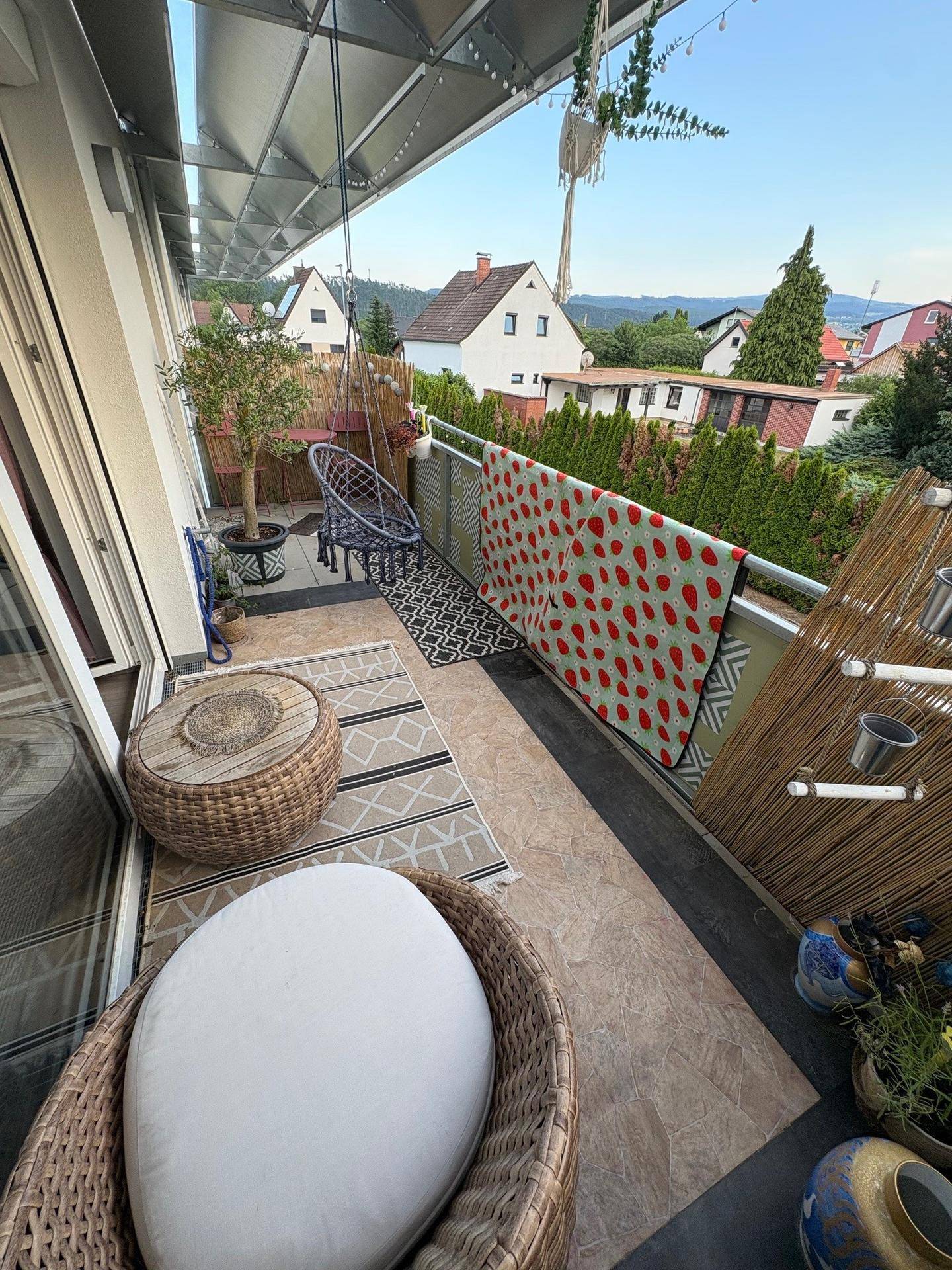 Schmaler Balkon mit Sitzgelegenheiten, Pflanzen und Blick auf die umliegende Landschaft.