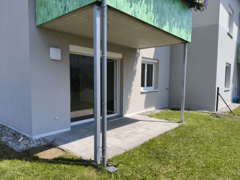 Erdgeschoss-Terrasse mit direktem Zugang zum Garten und darüberliegendem Balkon.