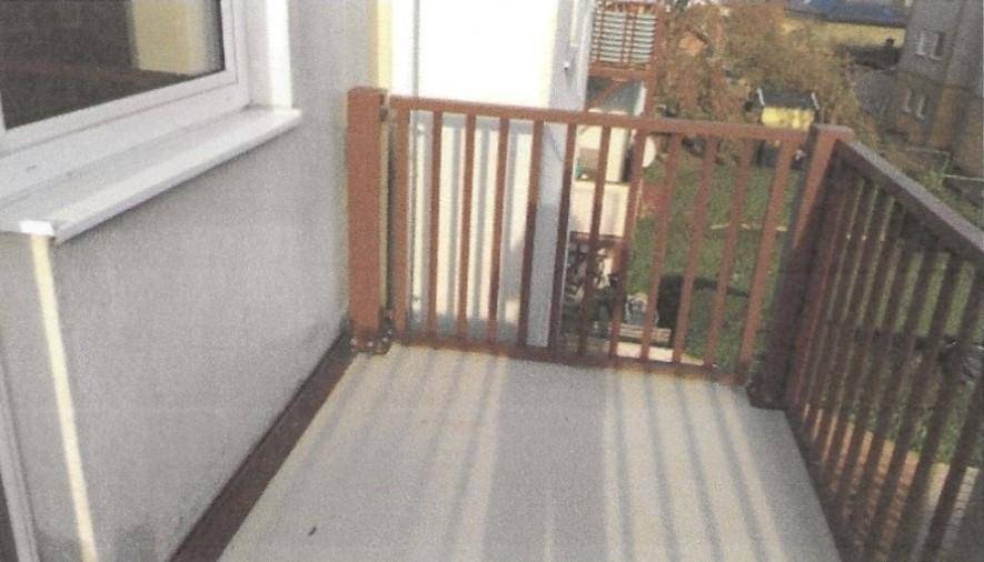 Kleiner Balkon mit Holzgeländer und Blick auf die Umgebung.
