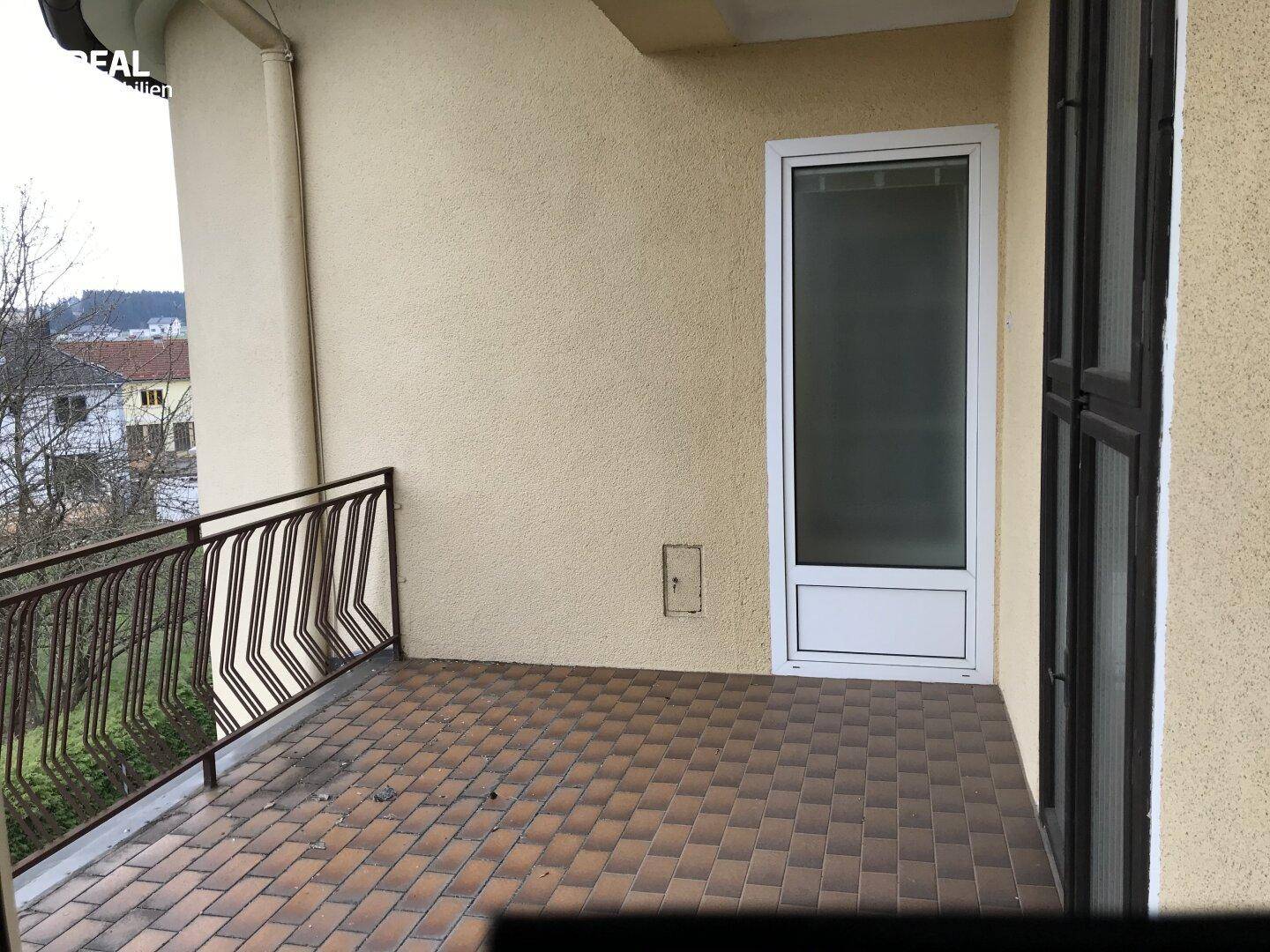 Geräumiger Balkon mit Fliesenboden und Blick auf die Umgebung.