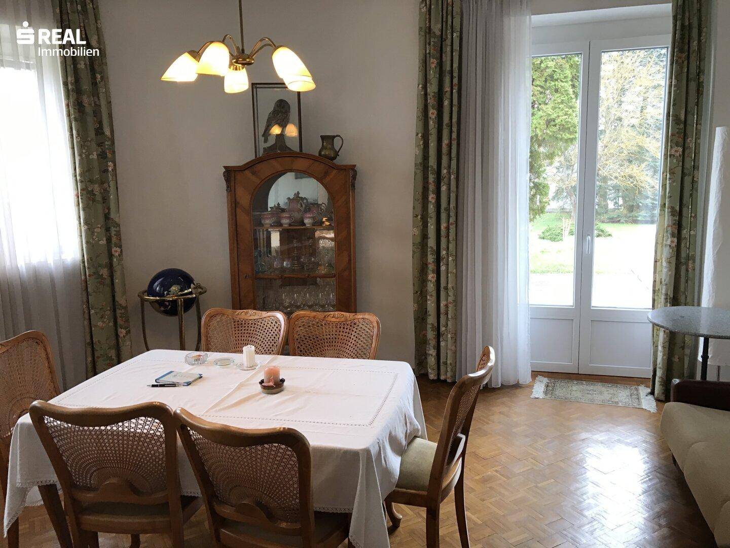 Esszimmer mit Zugang zum Garten oder zur Terrasse, ausgestattet mit traditionellen Möbeln.