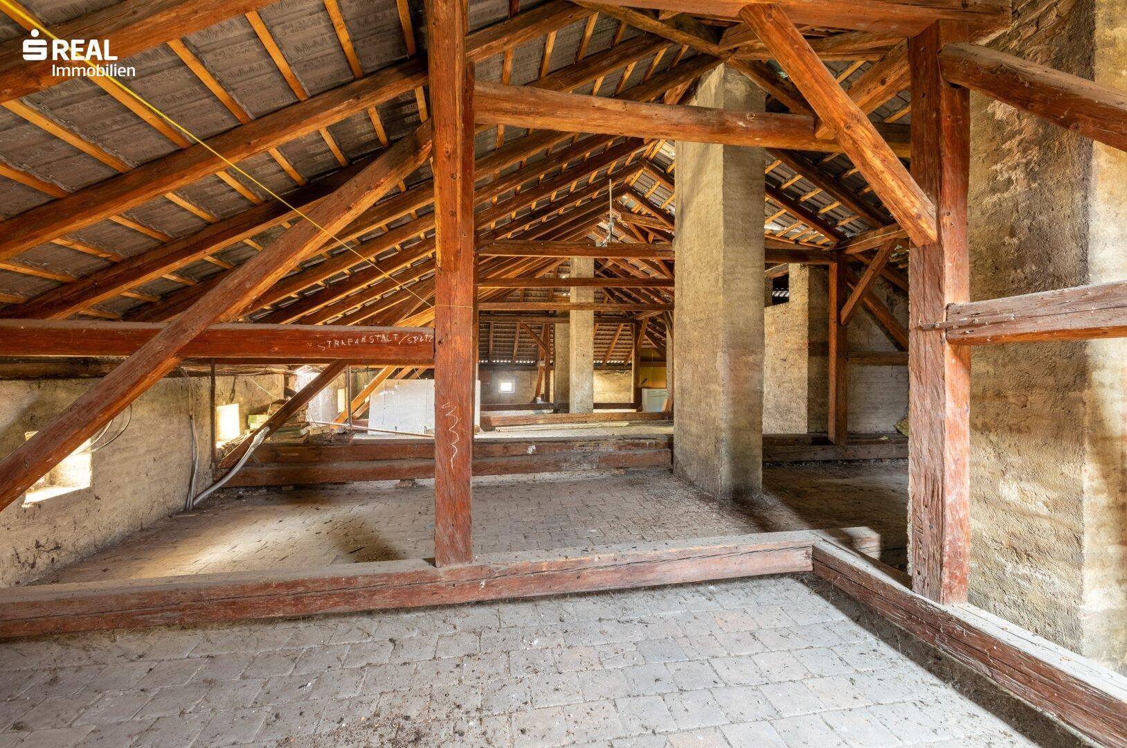 Geräumiger Dachboden mit sichtbaren Holzbalken und viel Potenzial für einen Ausbau.