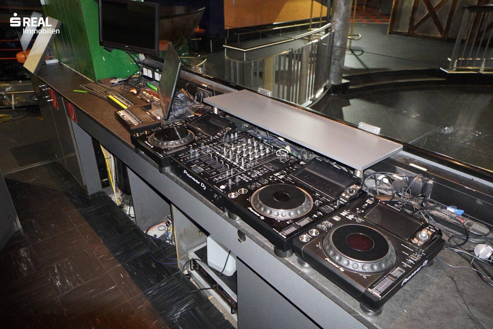 DJ-Pult mit professioneller Ausrüstung und Mischpulten für Musikveranstaltungen.