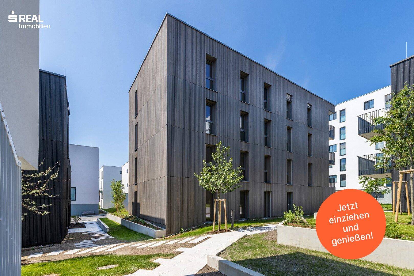 Zeitgenössisches Wohnhaus mit vertikaler Holzverkleidung und großen Fenstern in sonniger Umgebung.