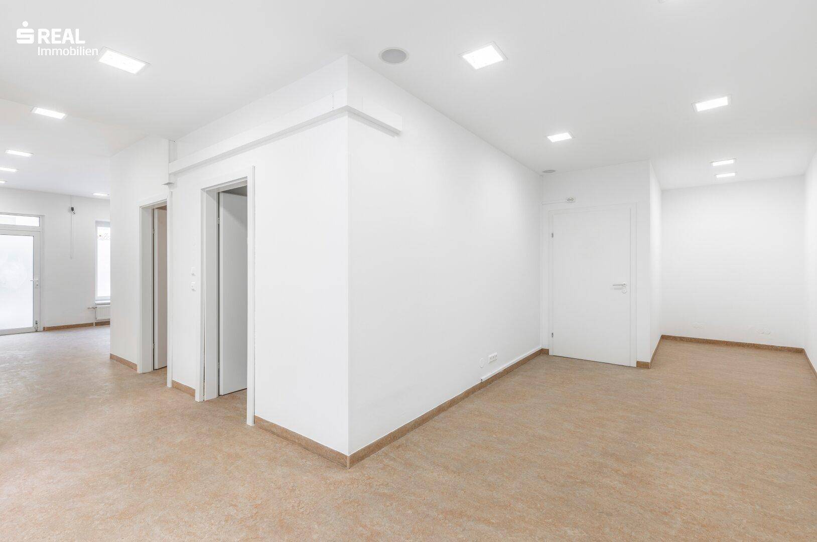 Heller, leerer Raum mit weißen Wänden und modernem Bodenbelag, ideal für Büronutzung.