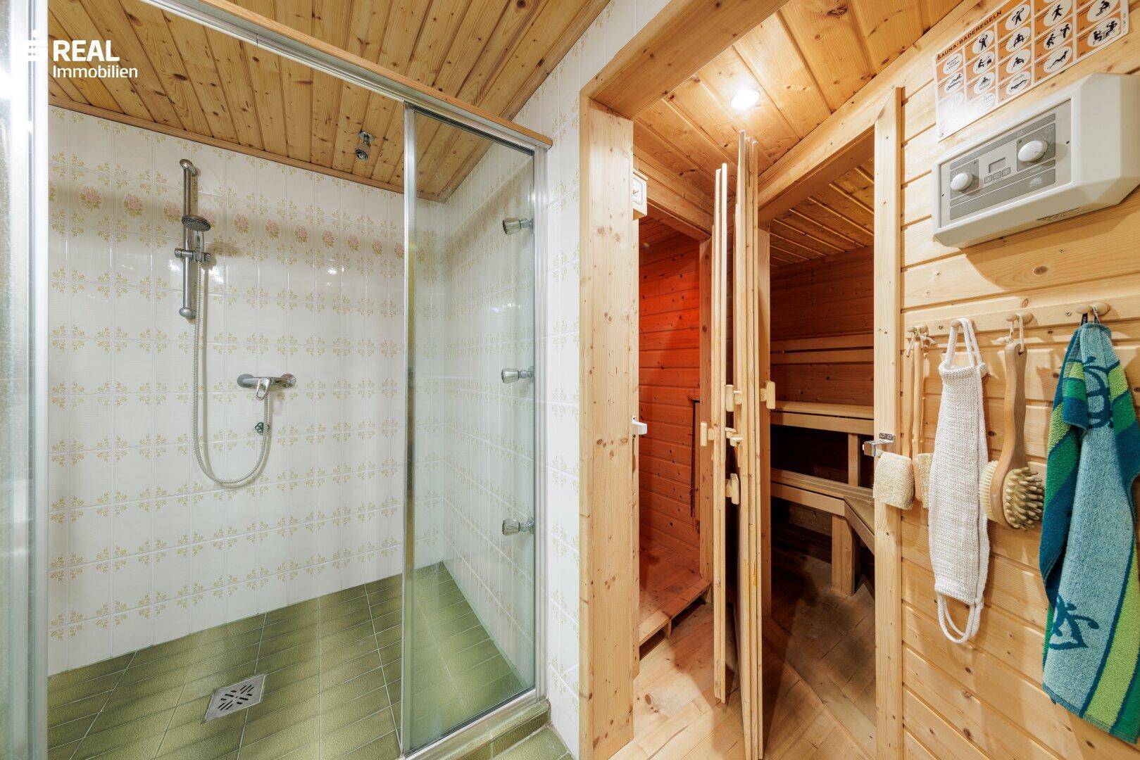 Wellnessbereich mit Duschkabine und einer traditionellen Holzsauna für Entspannung.