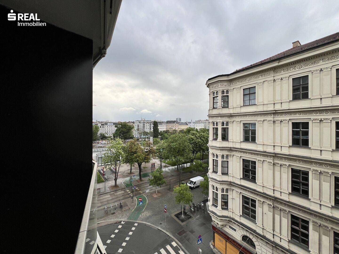 Weitblick über die Stadt mit grünen Bäumen und angrenzenden historischen Gebäuden.