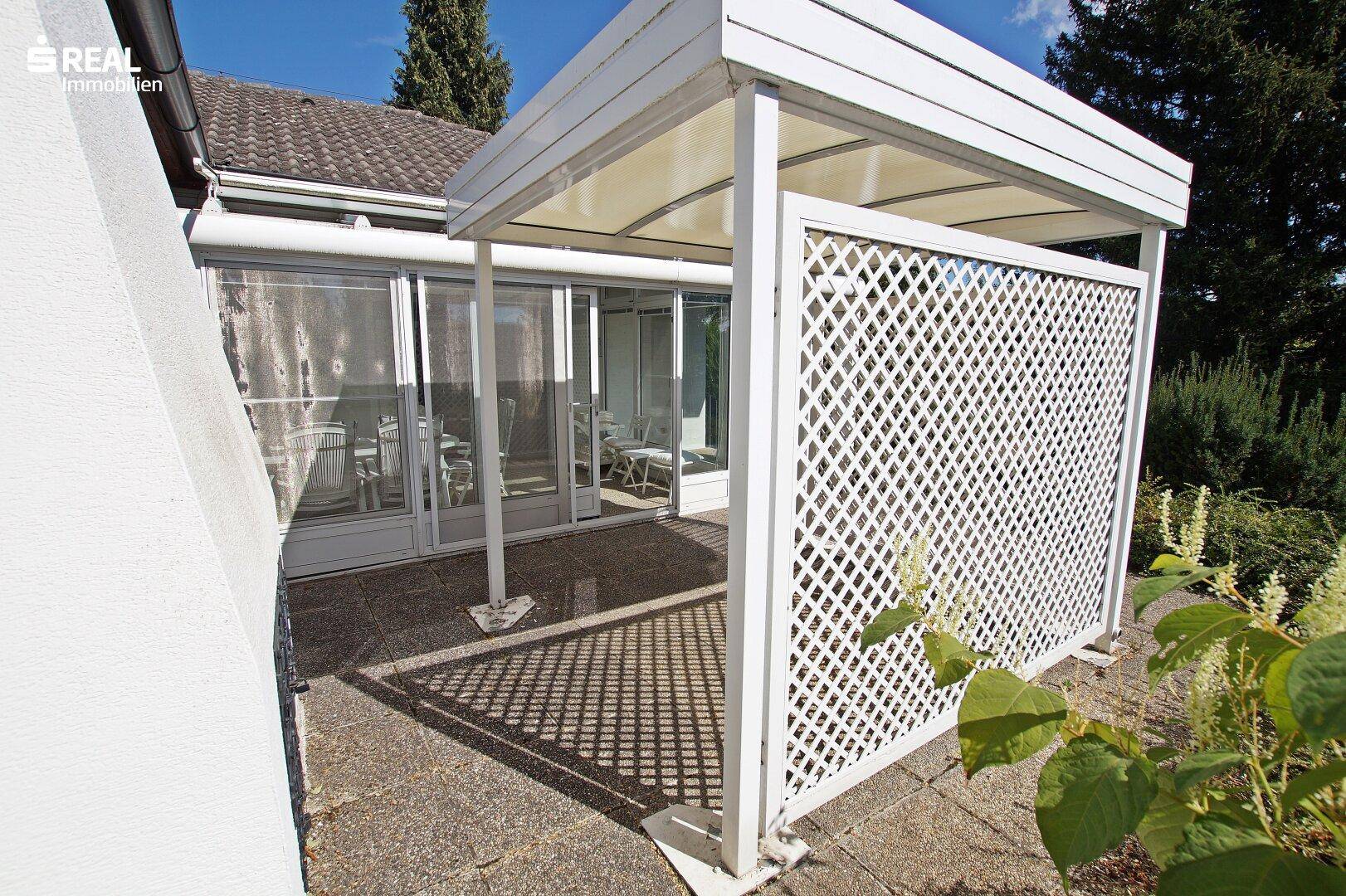 Überdachte Terrasse mit Sichtschutz und direktem Übergang zum Wintergarten.