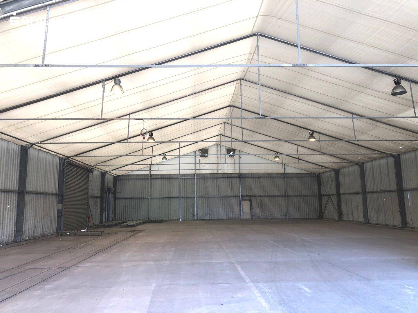 Große Zeltlagerhalle mit hoher Decke, Metallkonstruktion und Betonboden.