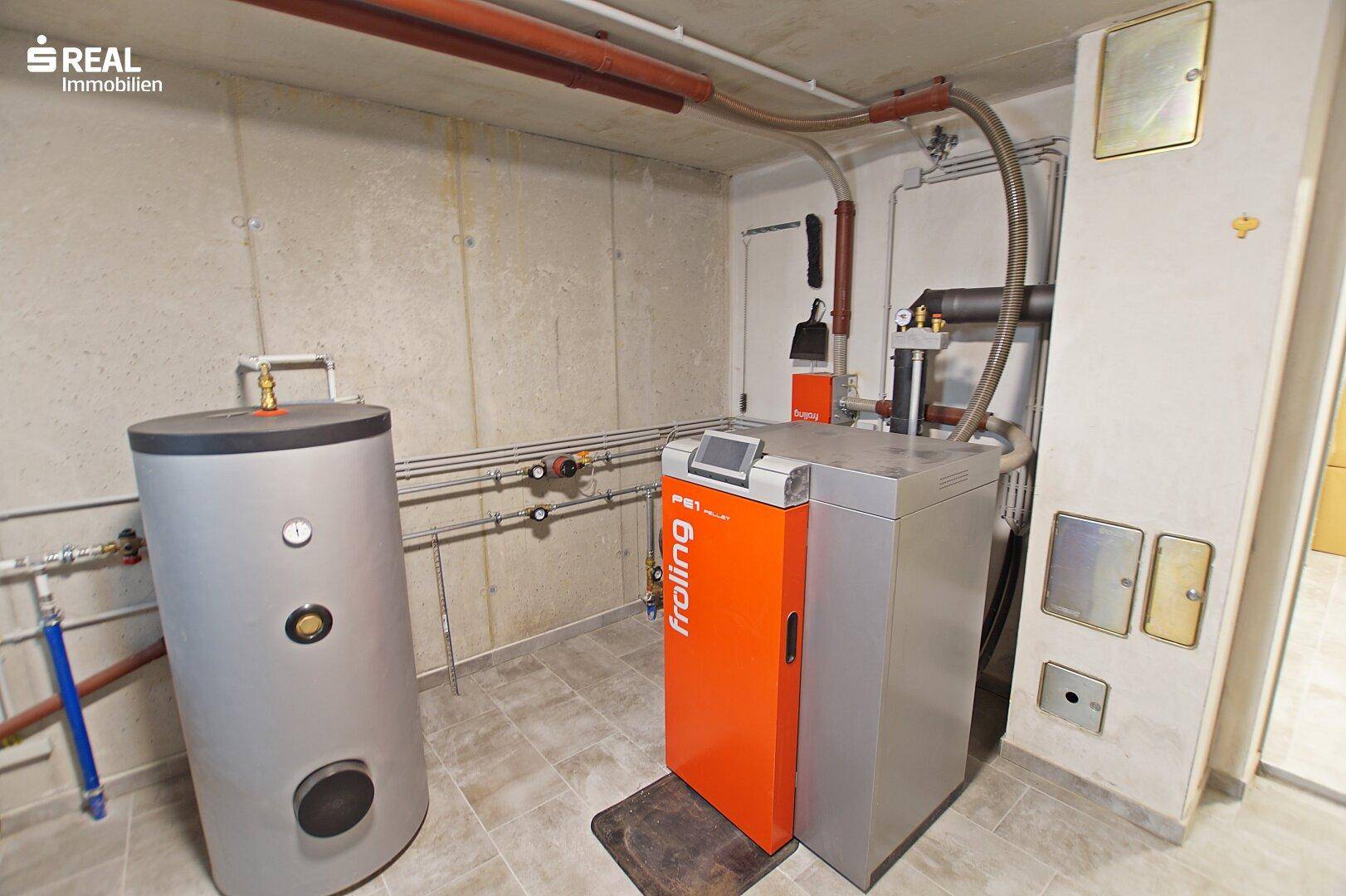 Heizraum mit moderner Pelletheizung und Warmwasserspeicher.