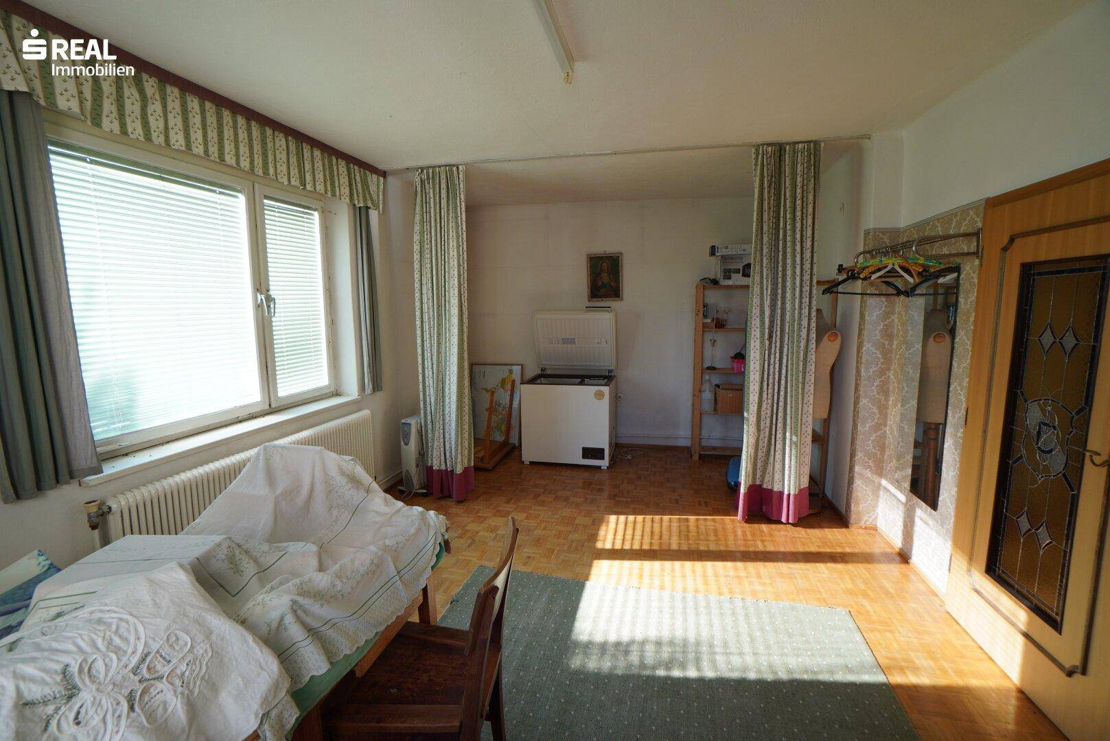 Mehrzweckraum mit Fenster, Gefriertruhe und Stauraum.