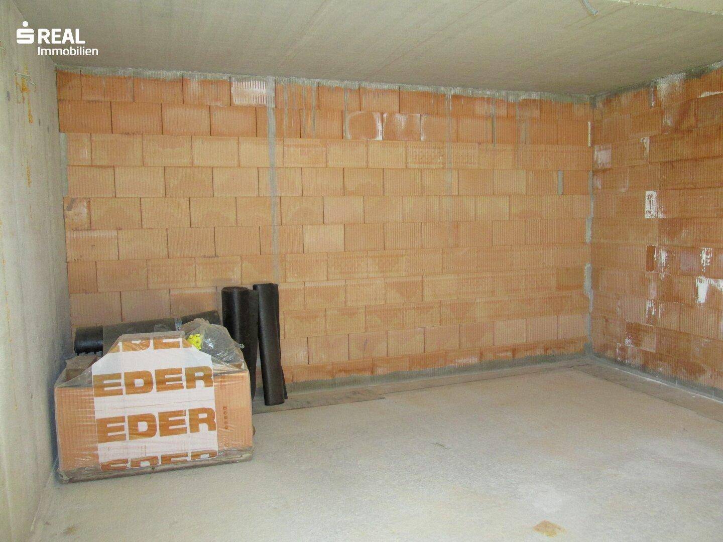 Geräumiger Kellerraum mit Betonwänden und Ziegelmauerwerk, bereit für den weiteren Ausbau.